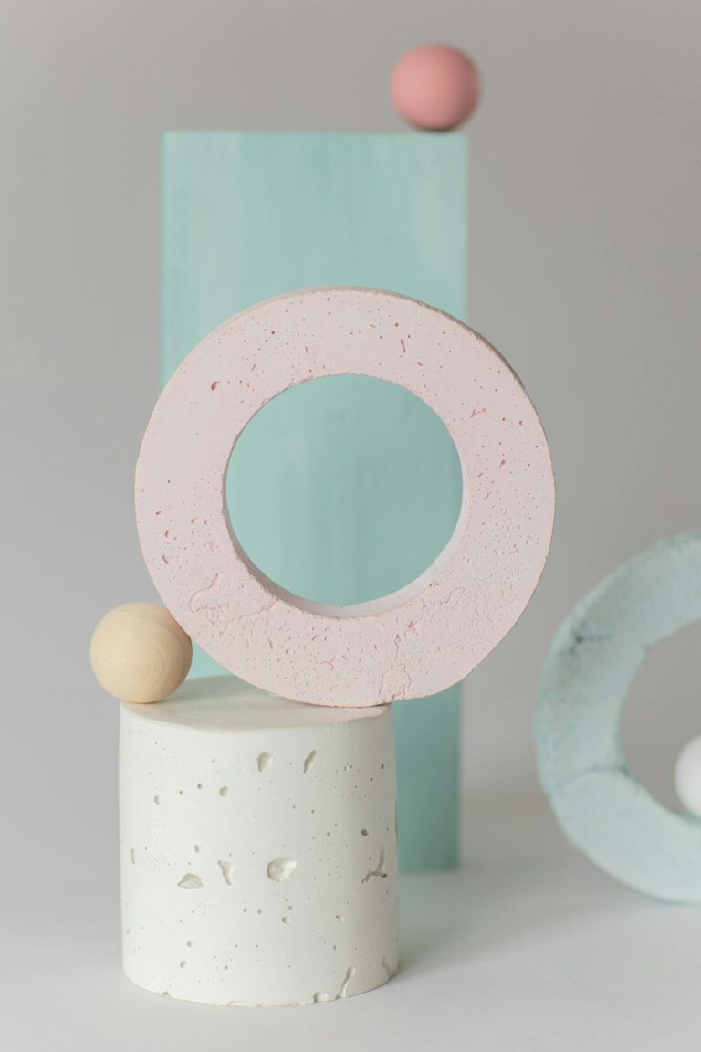 A minimalist composition of colorful geometric shapes arranged in a pastel abstract still life.