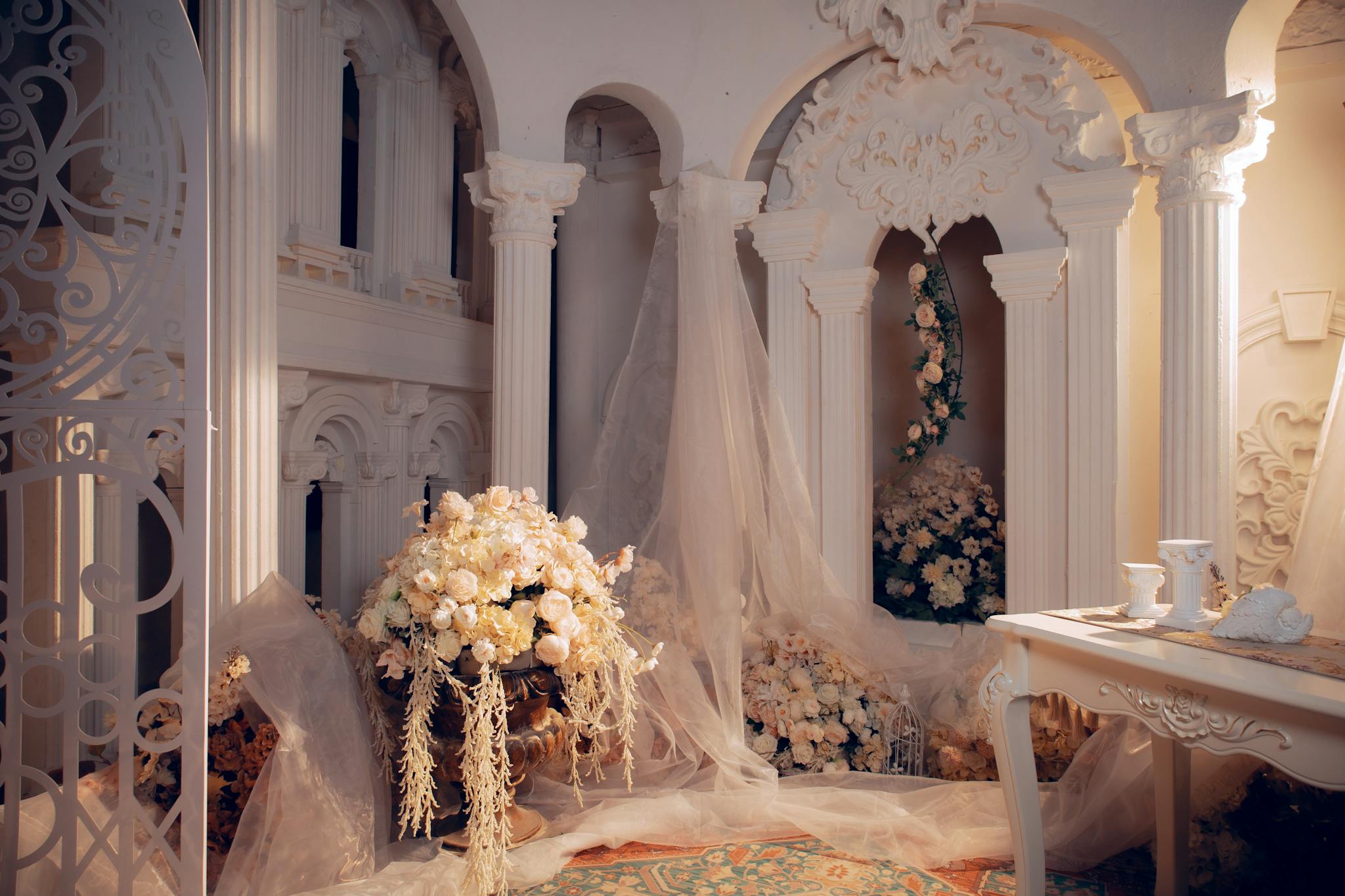 Luxurious wedding room with ornate columns and elegant white floral decorations.
