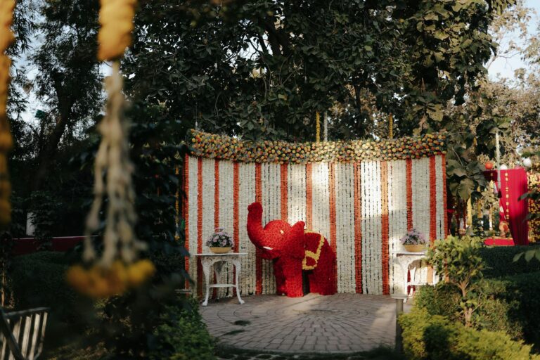 Vibrant floral elephant sculpture at a beautifully decorated outdoor event setting.