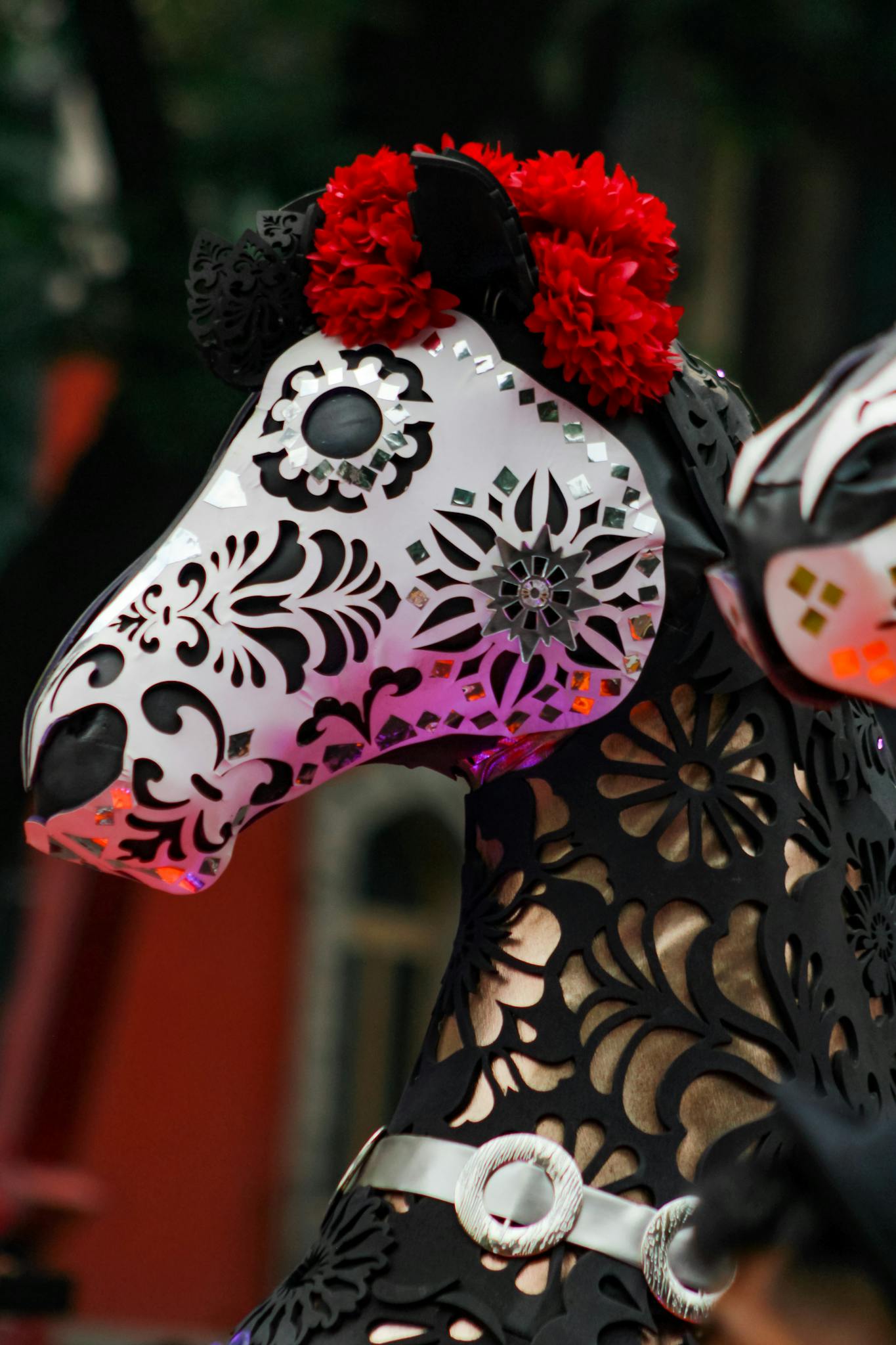 Vibrant horse mask adorned with red flowers, capturing festive cultural elements.